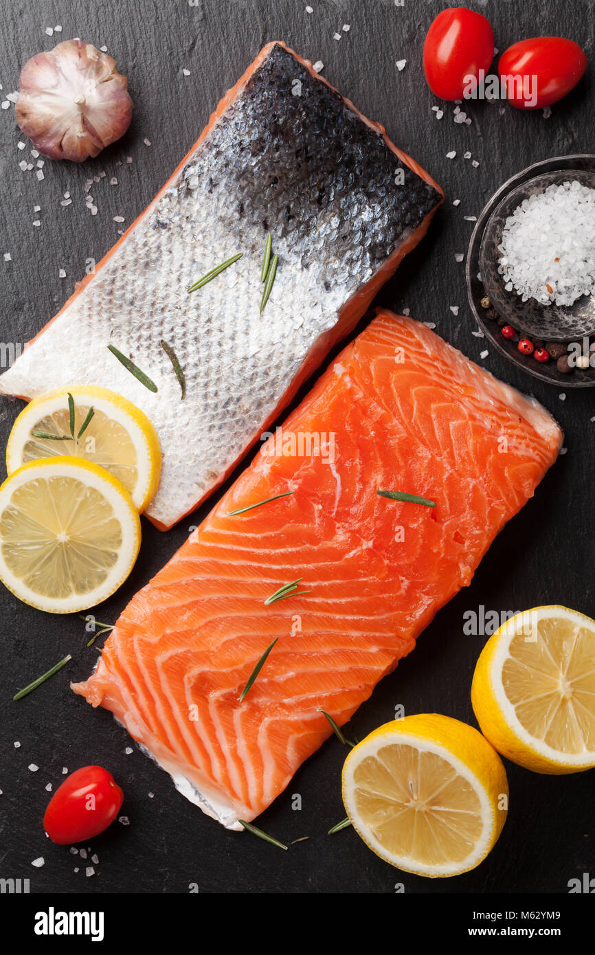 Raw salmon fish fillet with spices cooking on cutting board. Top view ...