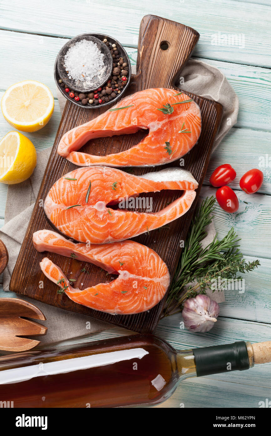 Raw salmon fish fillet with spices cooking on cutting board. Top view ...