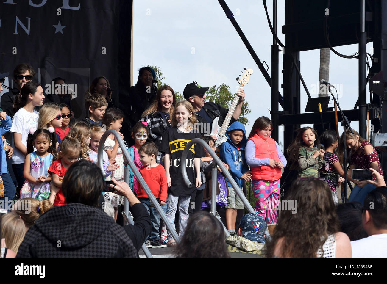 SAN DIEGO (Feb. 10, 2018) Actor, musician, and humanitarian Gary Sinise (center) and the Lt. Dan Band perform while surrounded by kids on stage at Naval Medical Center San Diego (NMCSD) during their sixth annual Invincible Spirit Festival. The festival included a three-hour concert by the band included activities for children, a rock-climbing wall, food cooked by Team Irvine, and 149 volunteers who set up and served food at the event. Gary Sinise and Lt. Dan Band debuted their first military concert at NMCSD in 2012. (U.S. Navy Stock Photo