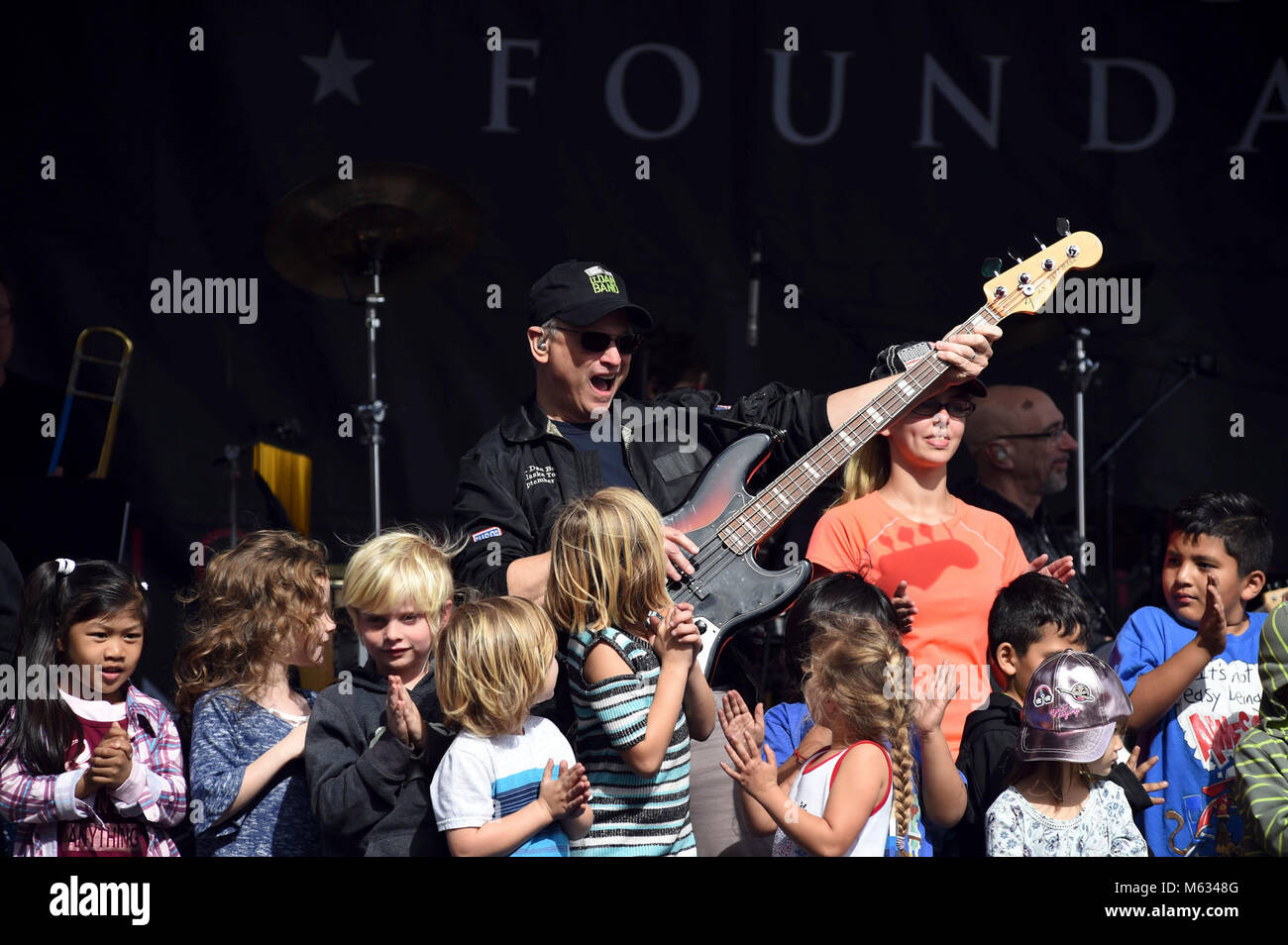 SAN DIEGO (Feb. 10, 2018) Actor, musician, and humanitarian Gary Sinise (center) and the Lt. Dan Band perform while surrounded by kids on stage at Naval Medical Center San Diego (NMCSD) during their sixth annual Invincible Spirit Festival. The festival included a three-hour concert by the band, activities for children, a rock-climbing wall, food cooked by Team Irvine, and 149 volunteers who set up and served food at the event. Gary Sinise and Lt. Dan Band debut their first military concert at NMCSD in 2012. (U.S. Navy Stock Photo