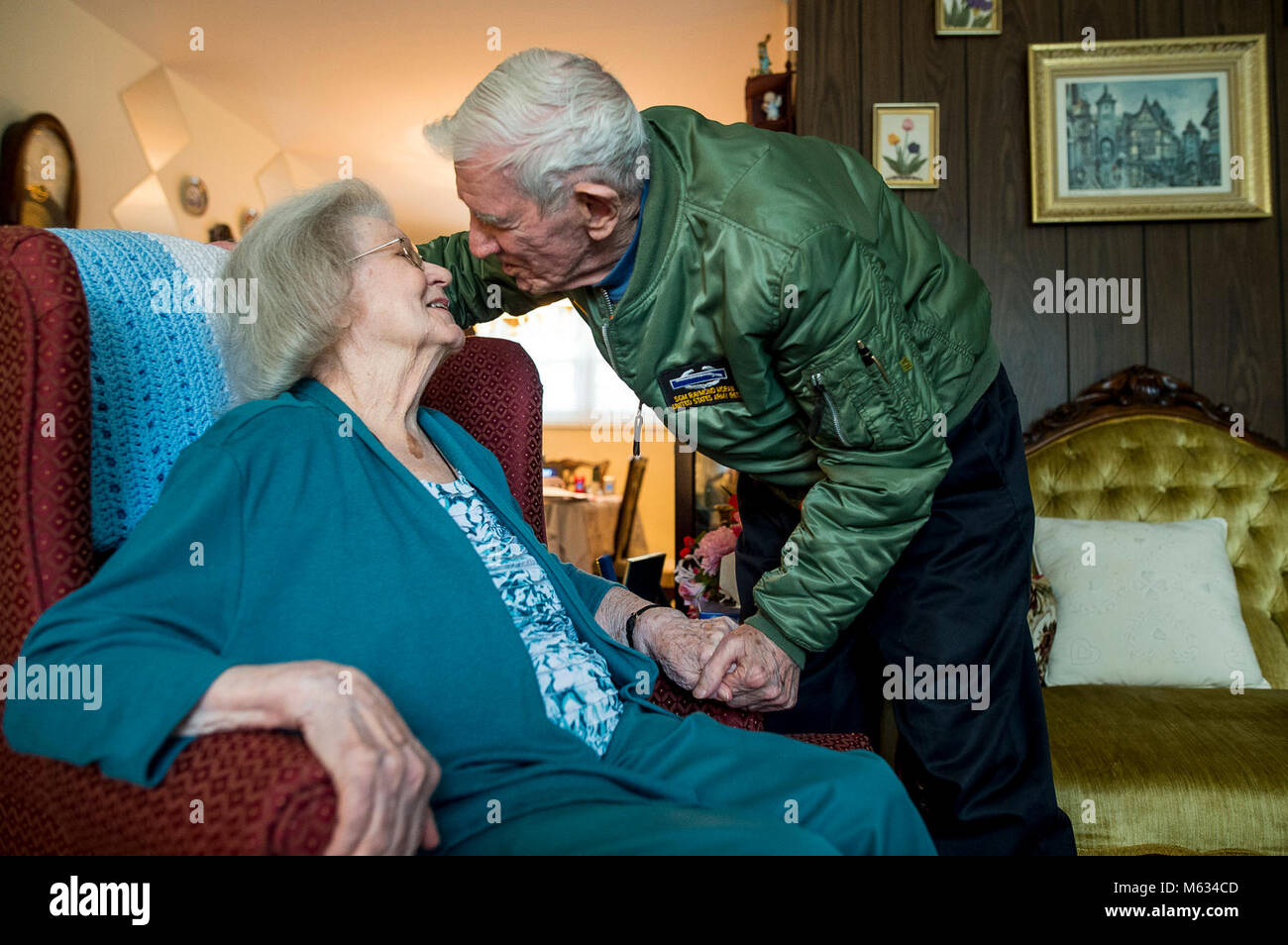 Sgt. Maj. Raymond Moran (Ret.), affectionately known as the 'Old Soldier,' leans in to kiss his wife, Barbara, of 65 years marriage at their home in Odenton, Maryland, Feb. 11, 2018. The Morans officially celebrate their wedding anniversary on Valentine's Day. They were married Feb. 14, 1953. Raymond is originally from Latrobe, Pennsylvania, and Barbara is from Slovan, Pennsylvania. With this milestone, their years of marriage match the same number of years Moran committed to service in the Army and Army Reserve. Raymond enlisted in 1948, and served in Korea, Vietnam, Japan, Cambodia and durin Stock Photo