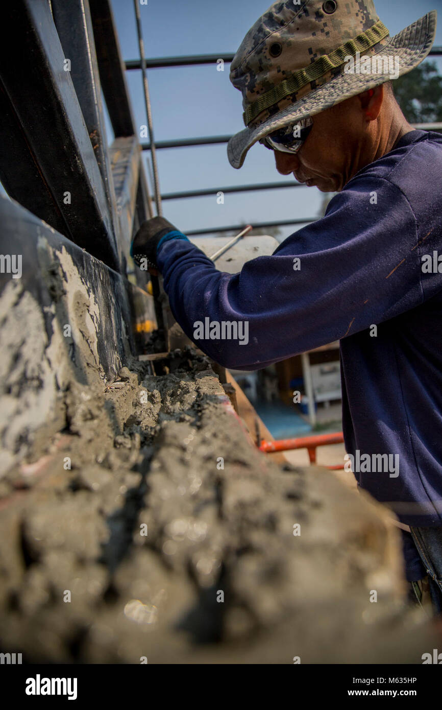 Royal Thai Navy Chief Petty Officer 1 Pairate Ruksawong, Construction Engineer Regiment, from Rayong province, Thailand, pours concrete during exercise Cobra Gold 2018, Feb. 7, 2018. Soldiers and sailors from the Royal Thai Navy, Singapore Army and U.S. Navy, worked together to build a multi-purpose class room for the Wat Sombum Naram school in Rayong province, Thailand. Cobra Gold 2018 maintains focus on humanitarian civic action, community engagement and medical activities conducted during the exercise to support the needs and humanitarian interests of civilian populations around the region. Stock Photo