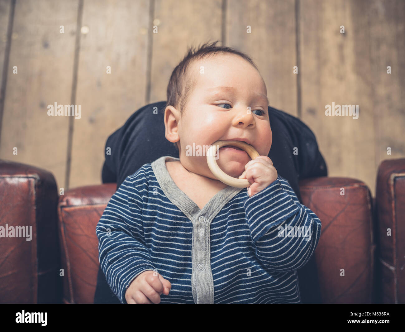 A little baby is chewing on a teething ring Stock Photo