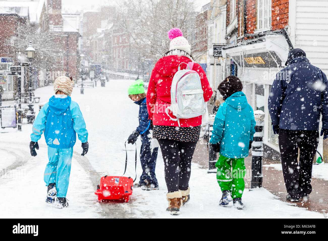 With local schools closed due to the bad weather a family take time to go sledging, High Street, Lewes, Sussex, UK Stock Photo