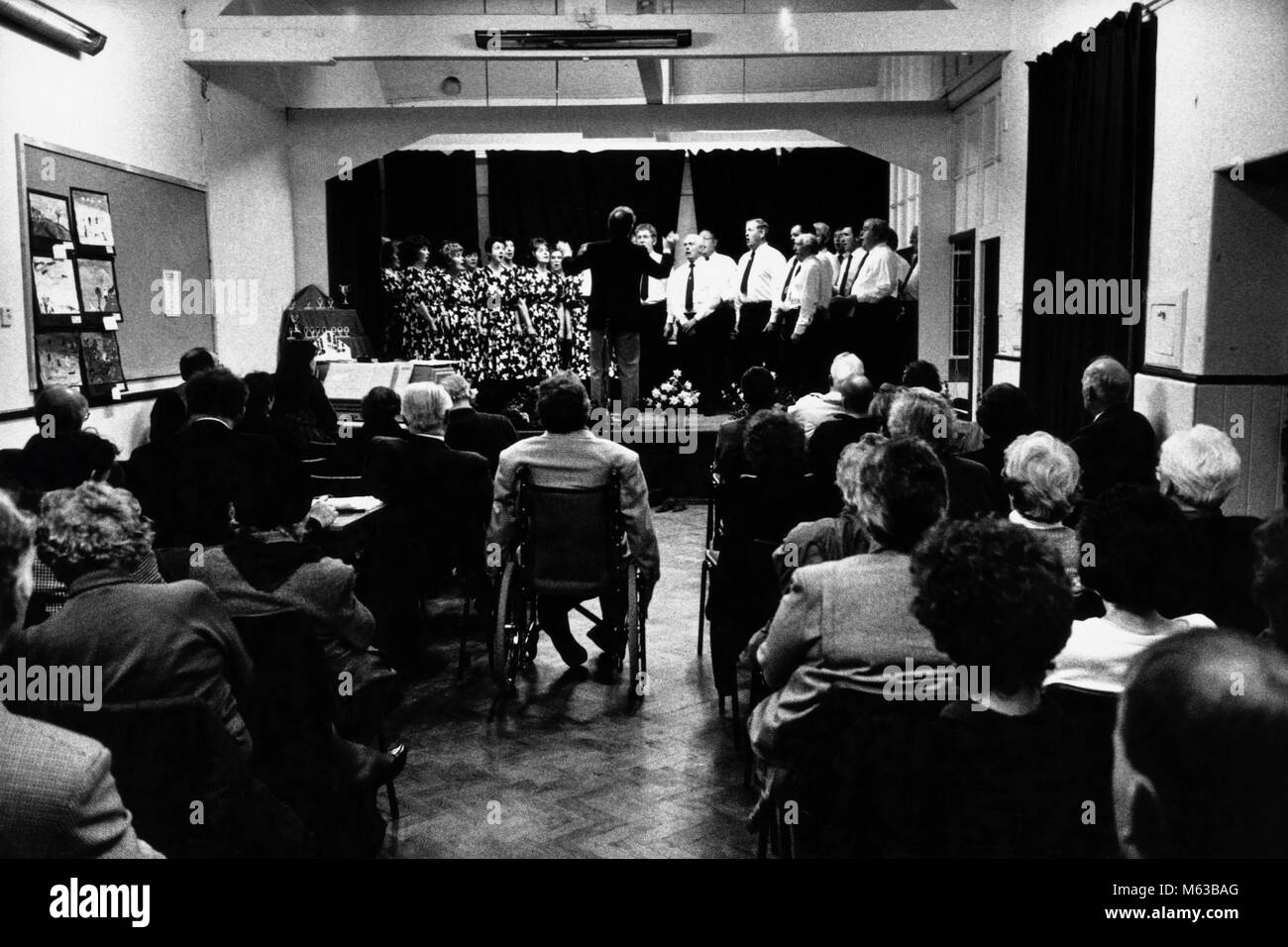 Choir singing on stage at small eisteddfod in village hall Talsarnau Gwynedd Wales UK Stock Photo