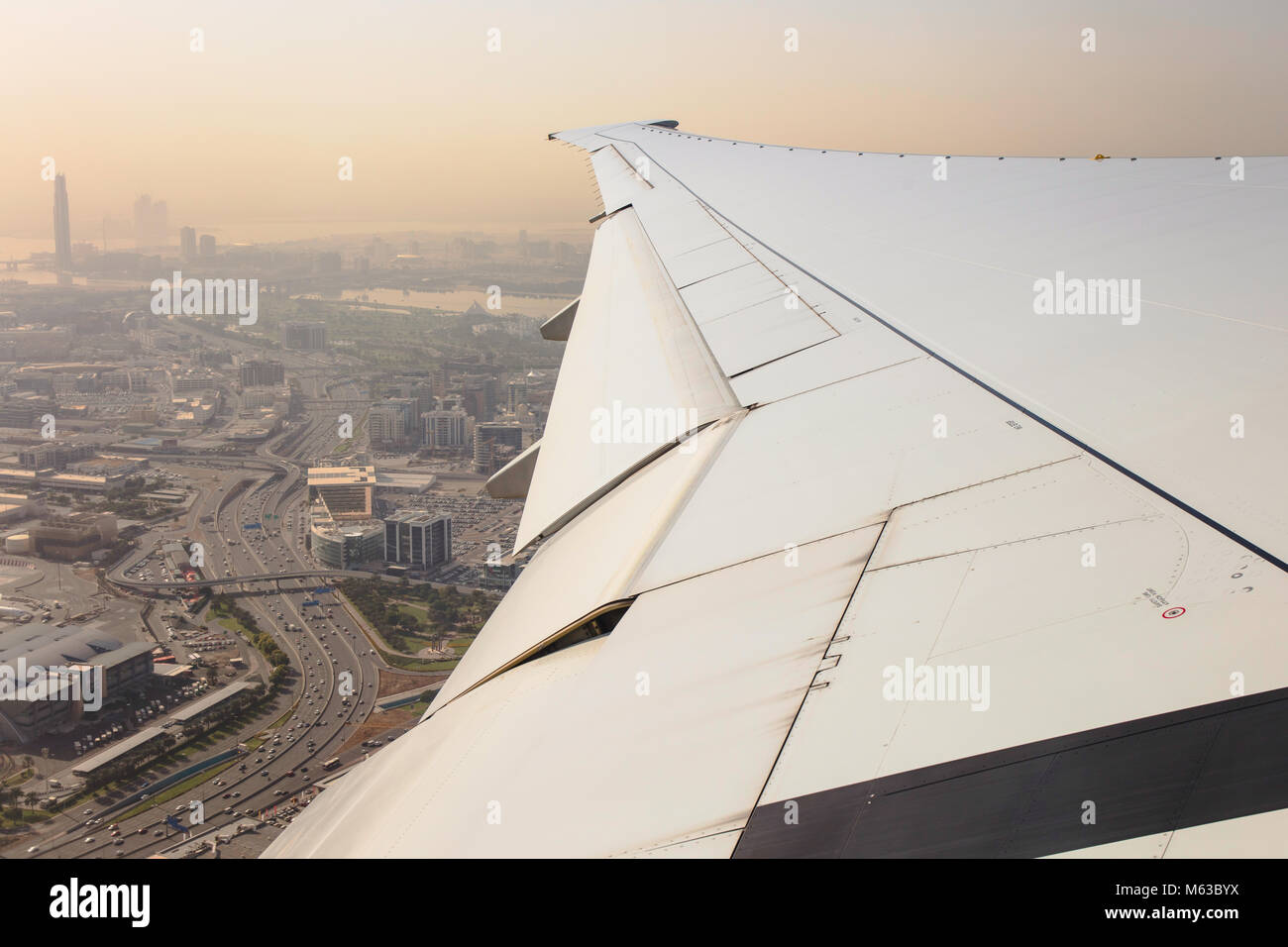 The wing of an Emirates Boeing 777 flying over Dubai after the take off, United Arab Emirates. Stock Photo
