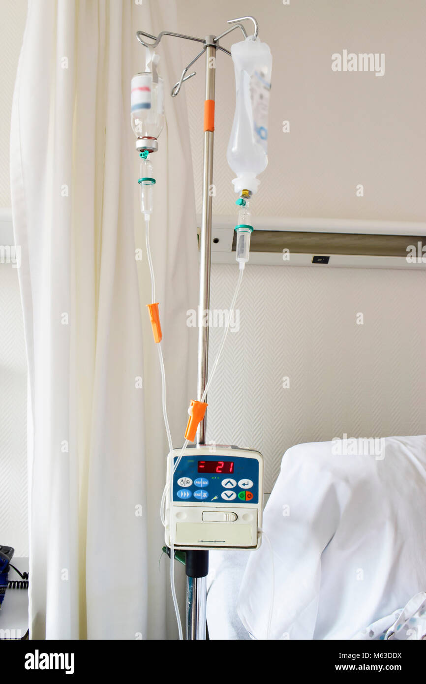 Infusion pump feeding IV drip in patient room in the hospital on