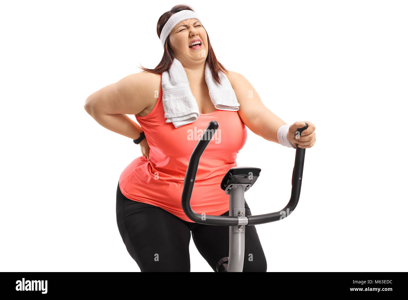 Overweight woman riding an exercise bike and experiencing back pain  isolated on white background Stock Photo - Alamy