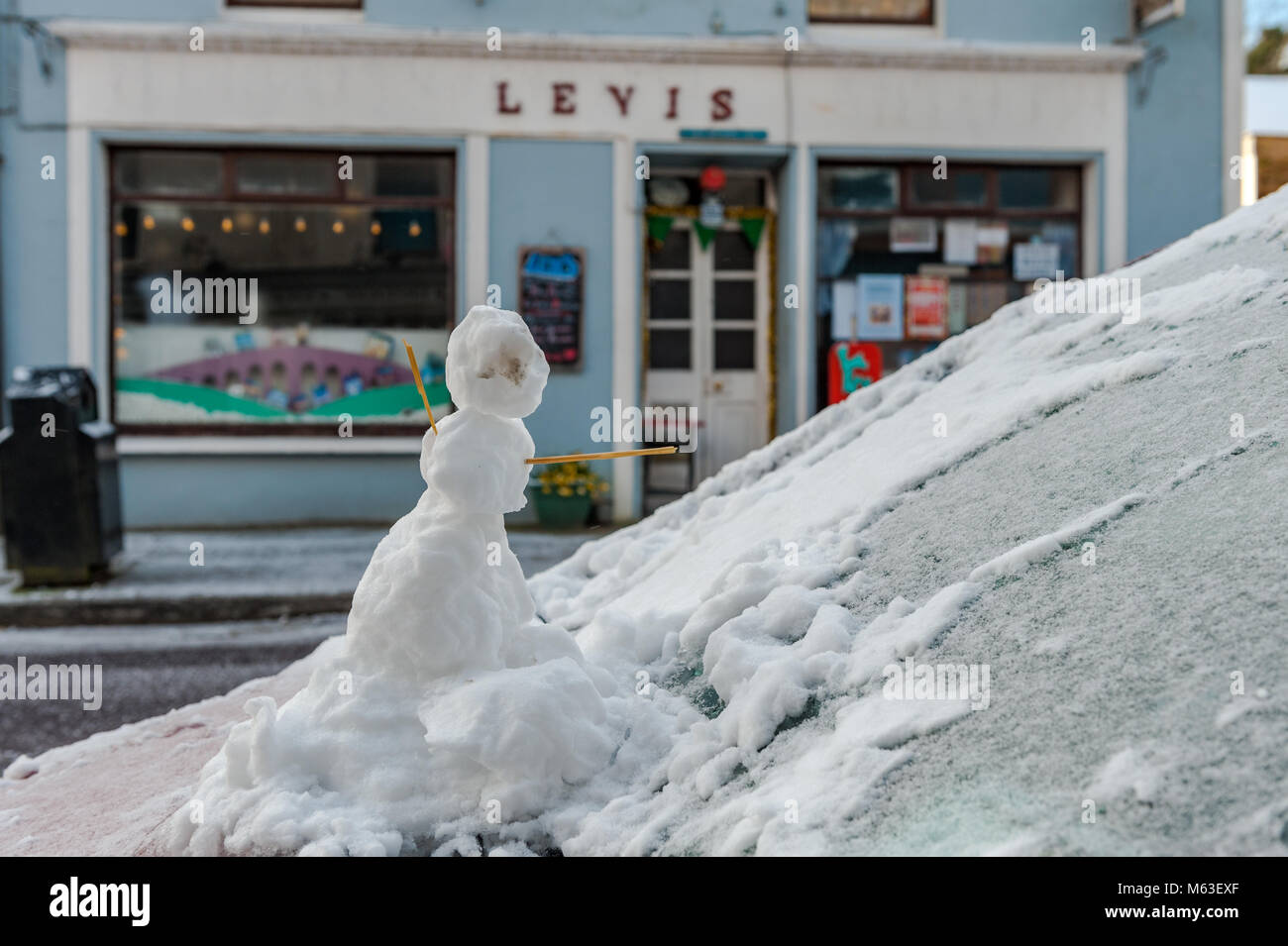 Small snowman on bonnet of car during Storm Emma in Ballydehob, West Cork, Ireland. Stock Photo