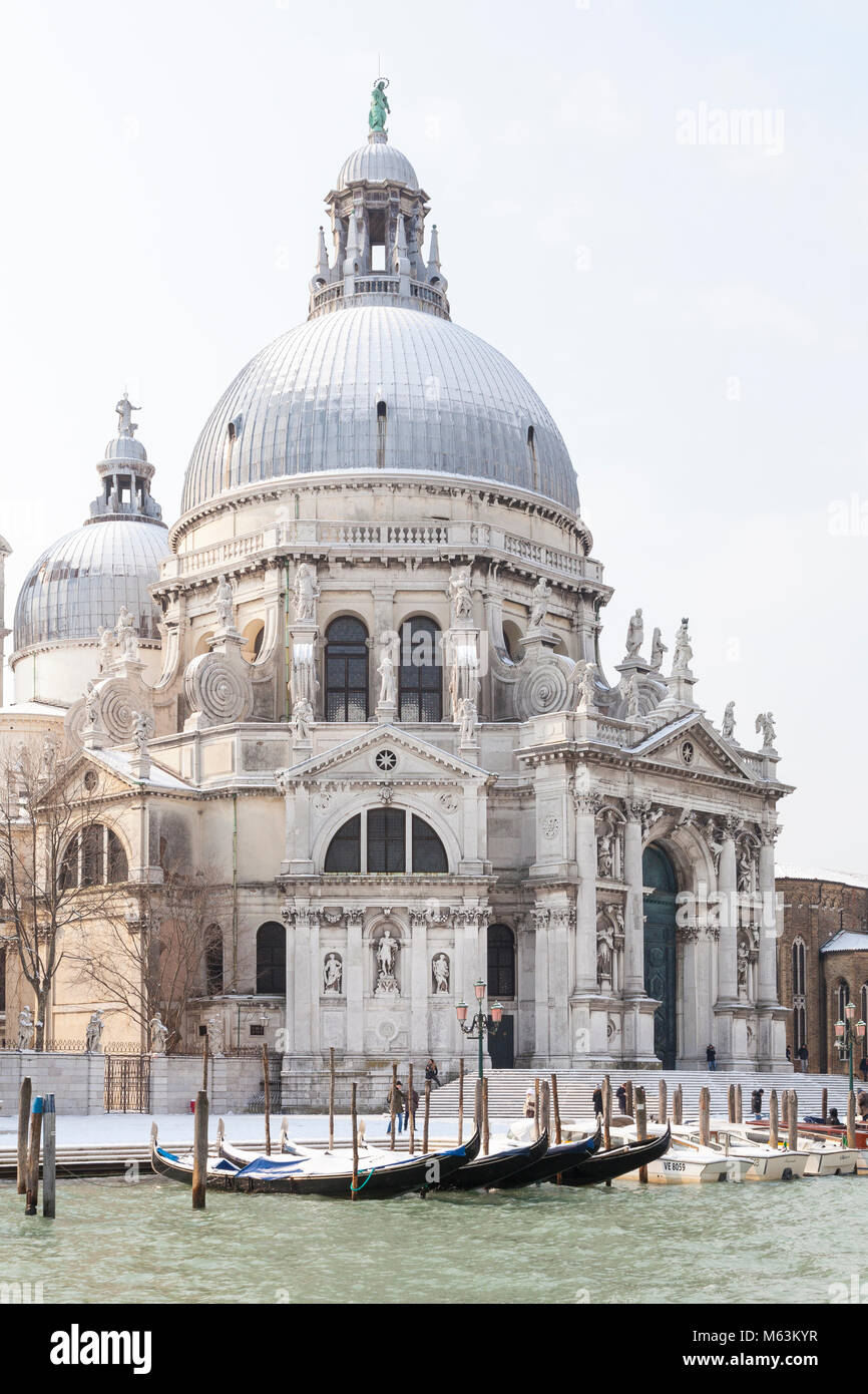 Venice, Veneto, Italy, 28th Fenbruary 2018. Rare snow in Venice caused by the Siberian weather front sweeping Europe, View of Basilica di Santa Maria della Salute and moored gondolas from the Grand Canal. Stock Photo