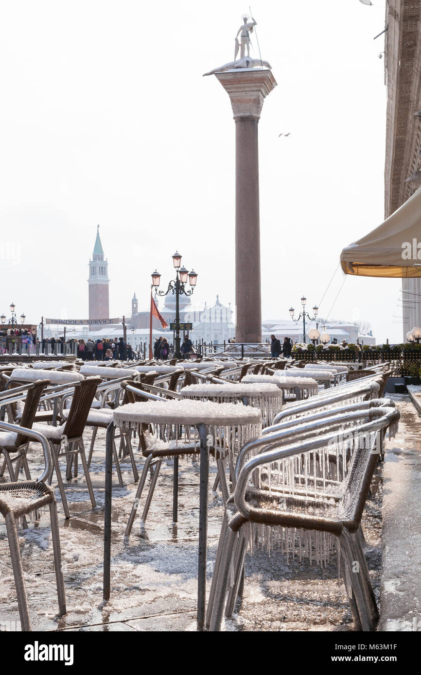 Venice, Veneto, Italy, 28th Fenbruary 2018. Rare snow in Venice caused by the Siberian weather front sweeping Europe, Icicles and ice crystals on tables and chairs in Piazza San Marco in front of the Cafe Chioggia. Stock Photo