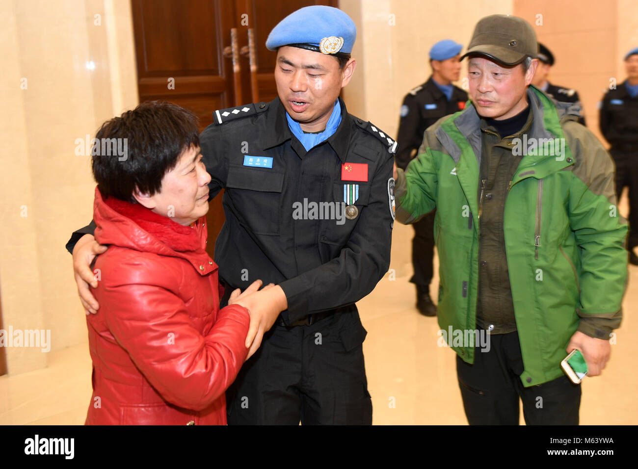 (180228) -- HANGZHOU, Feb. 28, 2018 (Xinhua) -- Chinese peacekeeper Han Zhuoqi (C) is greeted by his parents upon his arrival at the Hangzhou Xiaoshan International Airport in Hangzhou, capital of east China's Zhejiang Province, Feb. 27, 2018, after conducting a one-year mission in South Sudan. The sixth team of Chinese peacekeeping police to South Sudan, with seven members all selected from Zhejiang, arrived in Hangzhou Tuesday evening. In South Sudan, the police officers fulfilled a variety of tasks in the capital Juba and Wau, including patrols of refugee camps, humanitarian aid and communi Stock Photo