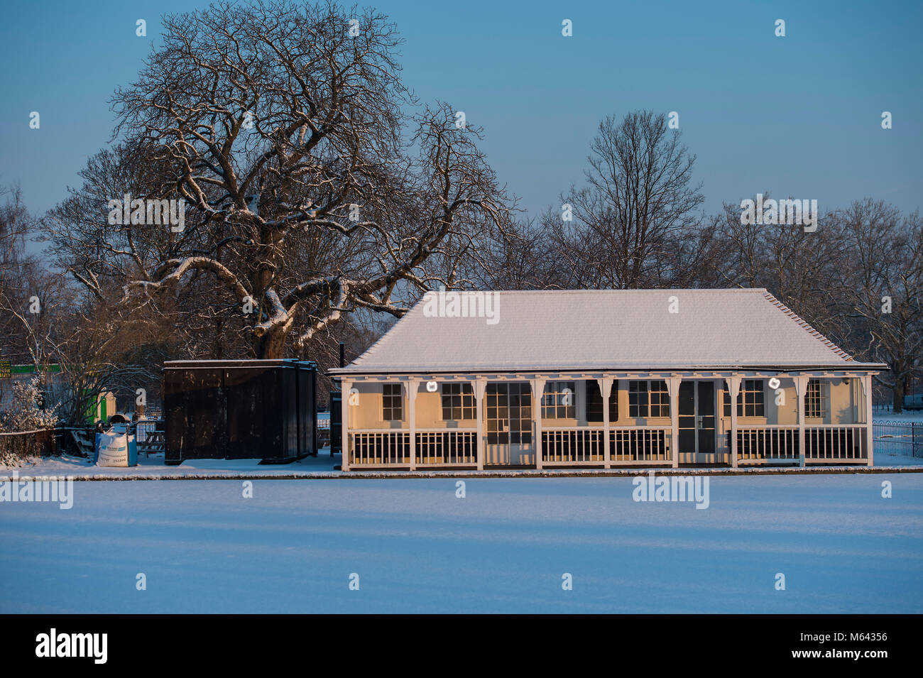 London, UK. 28th Feb, 2018. UK Weather: The Bowling Pavilion in the early sun - Families and commuters cross Clapham Common after the snow has fallen in freezing temperatures. Credit: Guy Bell/Alamy Live News Stock Photo