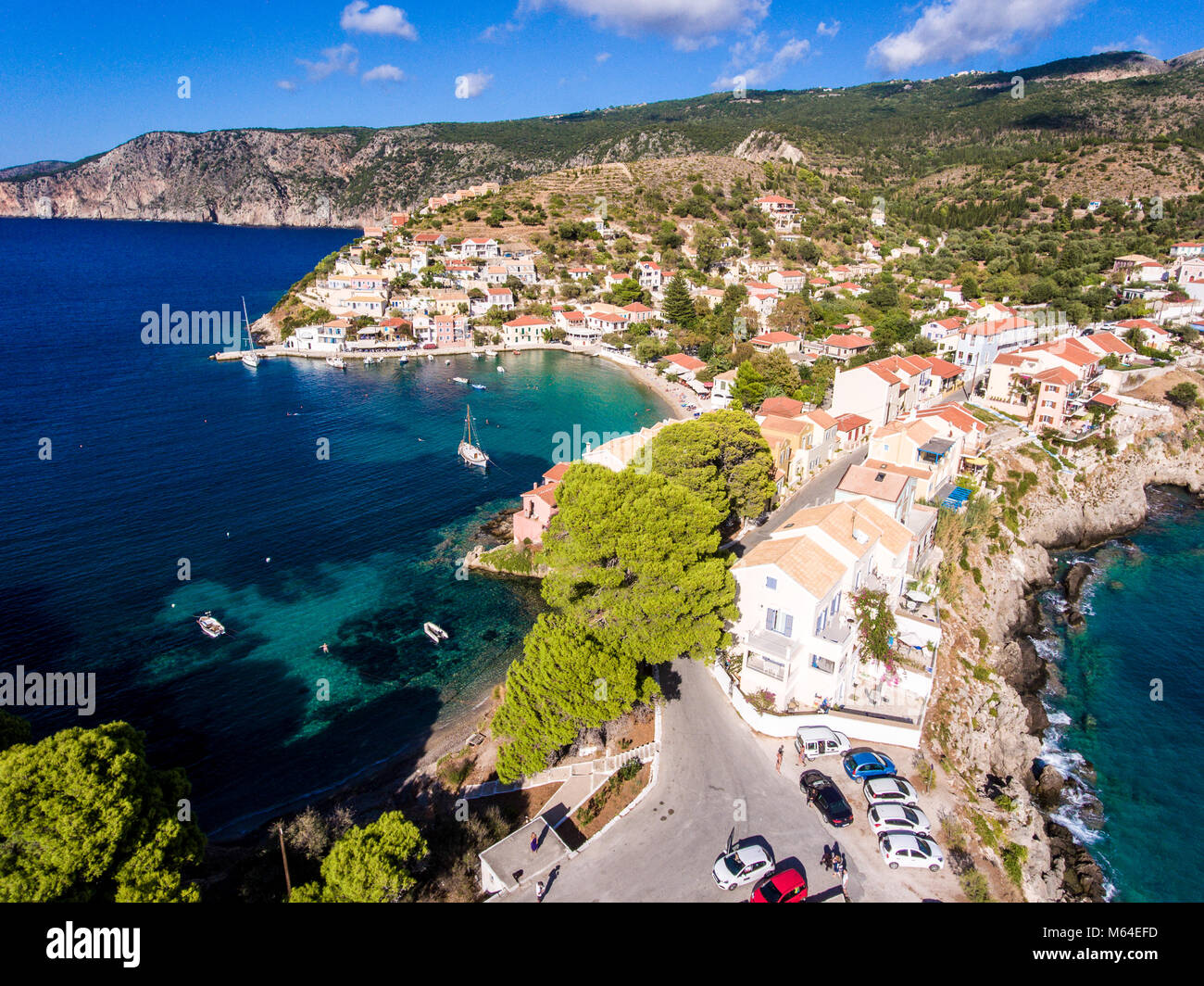 Aerial view over Assos Kefalonia beach with clear blue waters and yachts in harbour Stock Photo