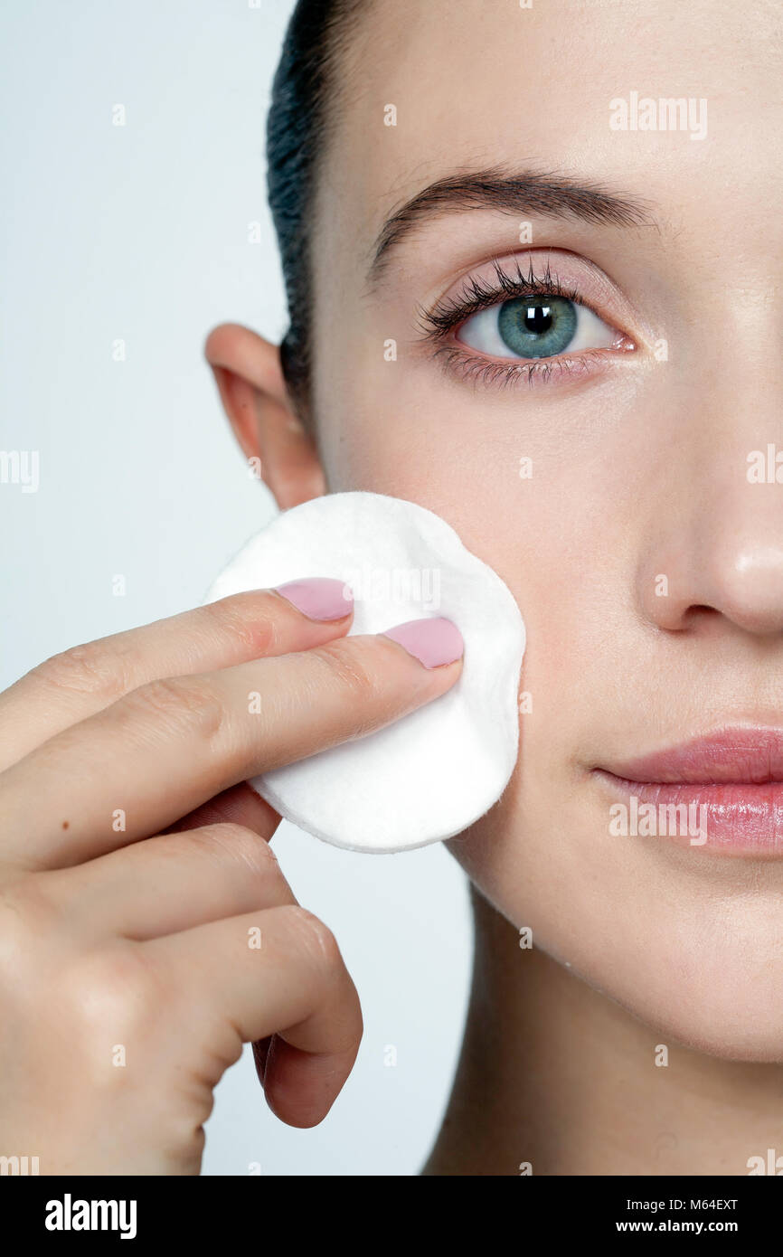 Cropped woman's face with cotton pad to cheek Stock Photo