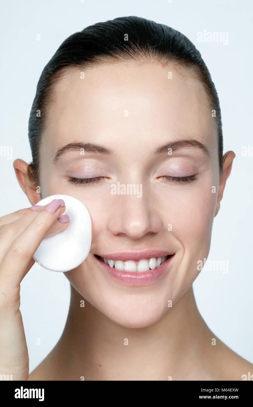 Woman with cotton pad to face Stock Photo