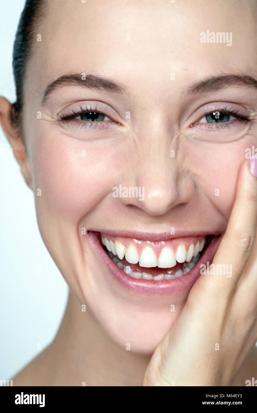 Happy woman with hand to face Stock Photo