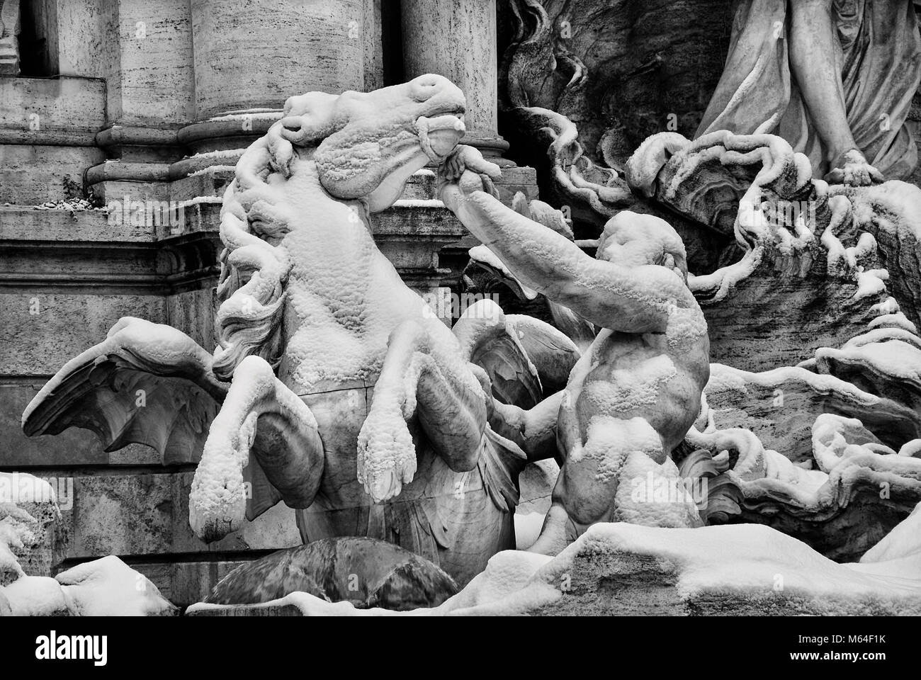 Trevi Fountain triton and sea horse marble statue covered by snow, a rare event of a city like Rome Stock Photo
