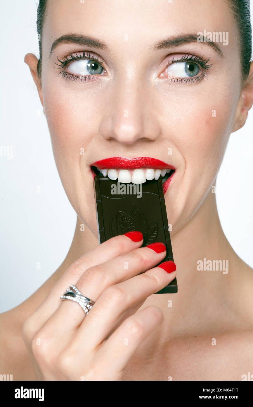 Woman eating dark chocolate Stock Photo