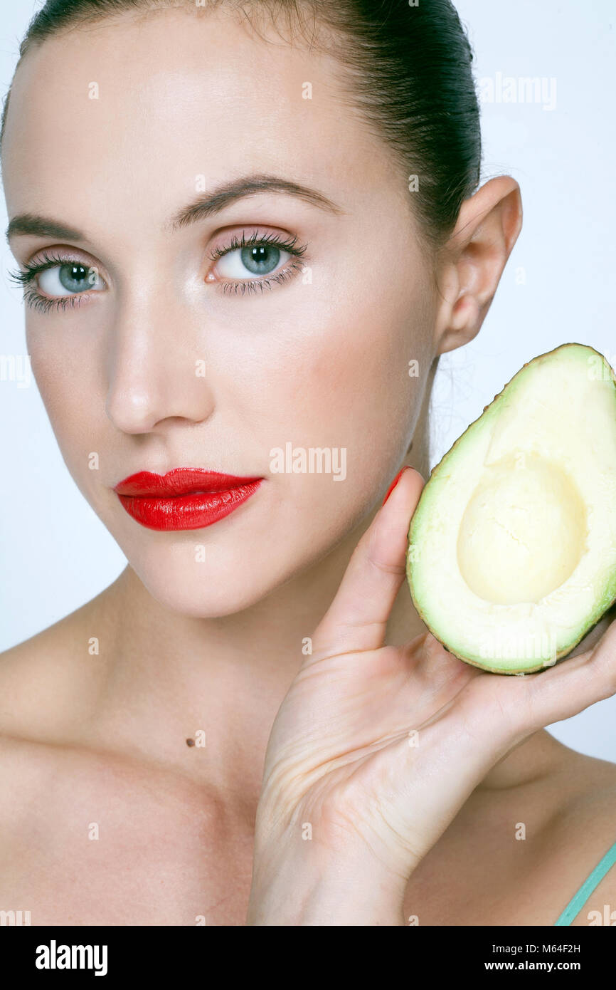 Woman holding avocado half Stock Photo