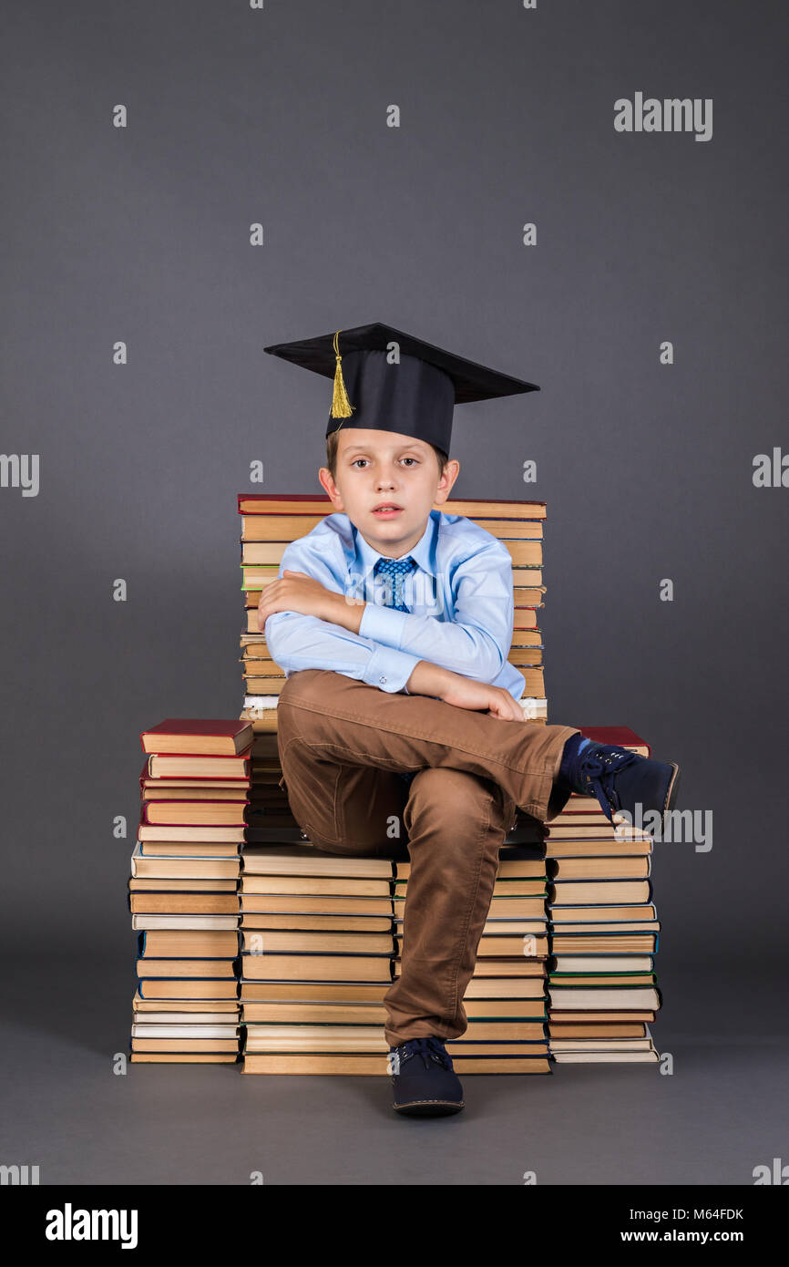 Education concept. Boy sitting on a throne from books with his legs cross Stock Photo