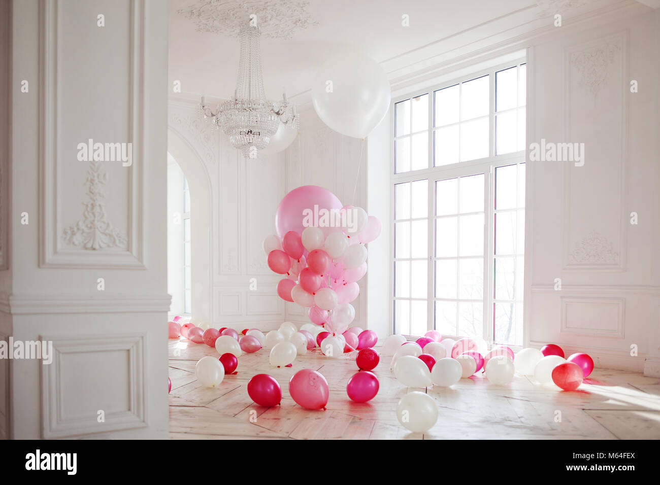 Luxurious living room with large window to the floor. The Palace is filled with pink balloons Stock Photo