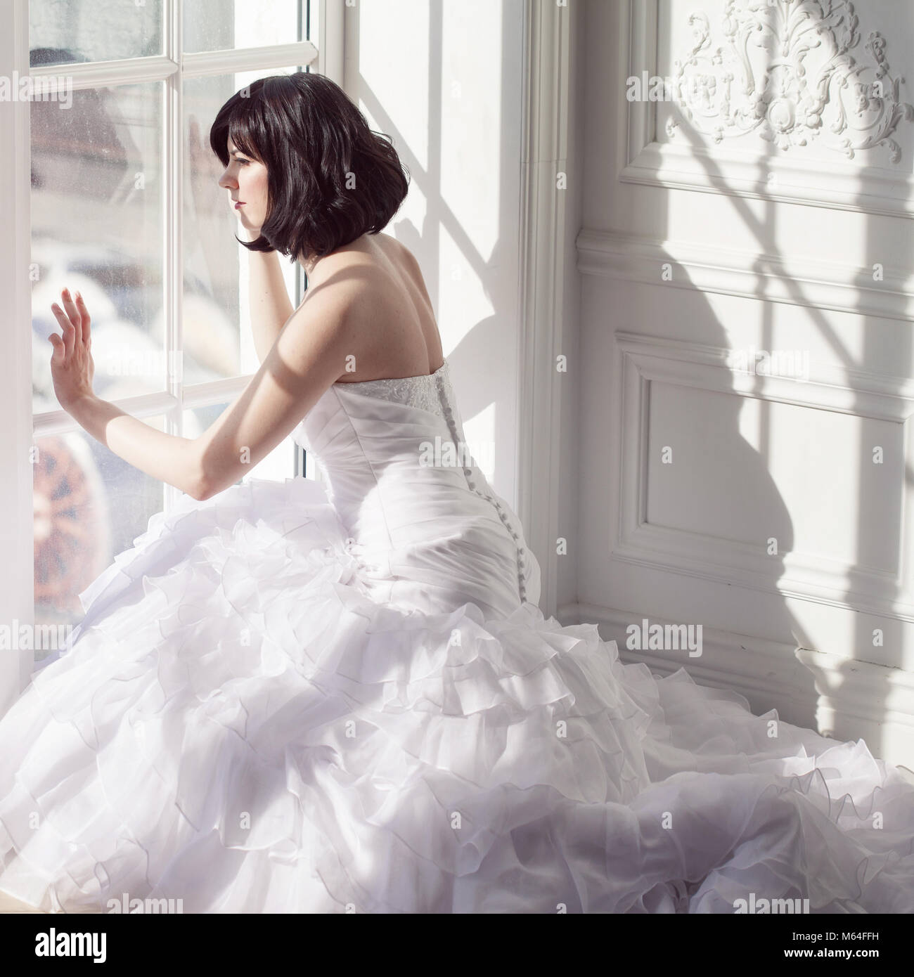 Portrait of young attractive brunette with short hair in a wedding dress. Stock Photo