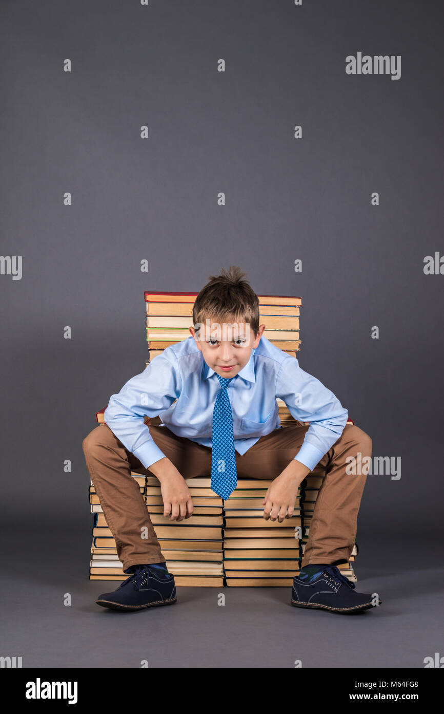 Education concept. Happy boy sitting on a throne from books Stock Photo