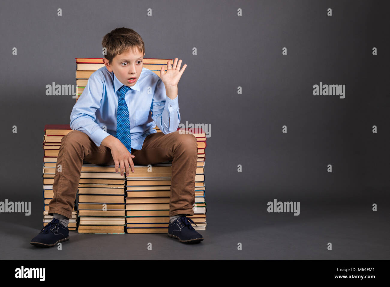 Education idea. The boy sitting on the throne from the books, who was suddenly visited by a brilliant idea Stock Photo