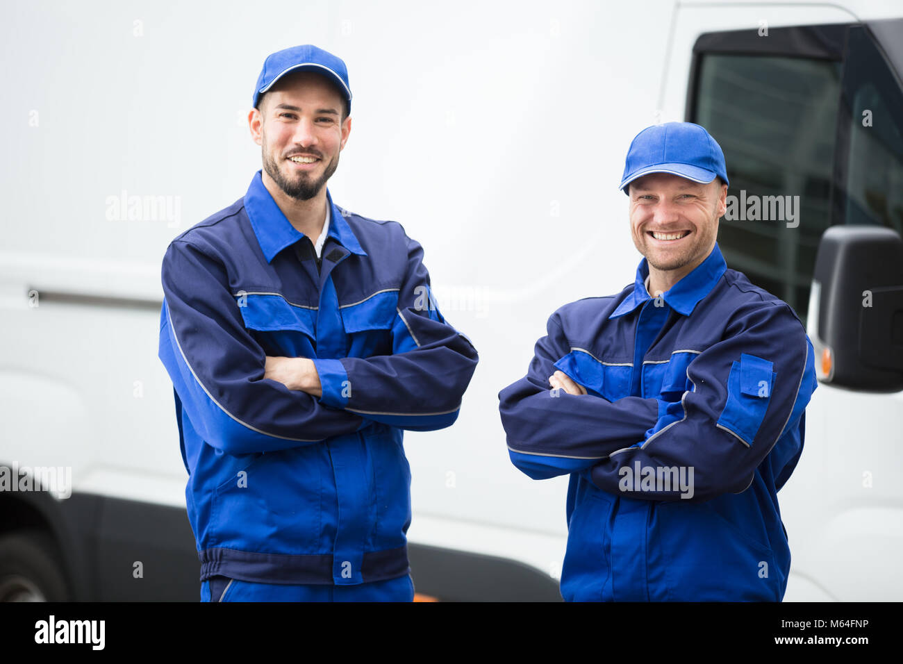Portrait Of A Happy Male Workers Standing With Folded Arms Stock Photo