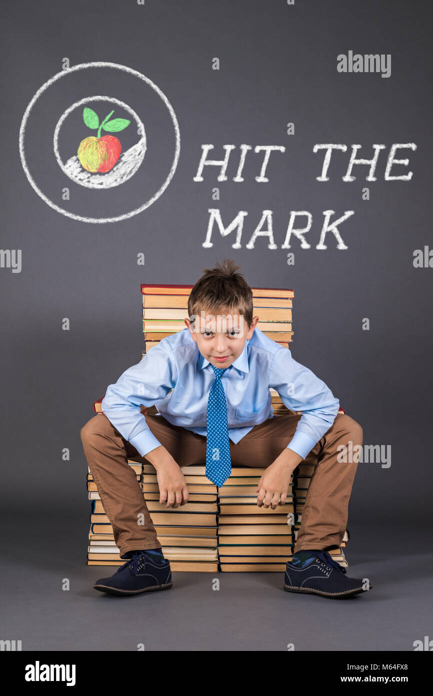 Hit the mark. Funny education concept with happy boy sitting on a throne from books Stock Photo