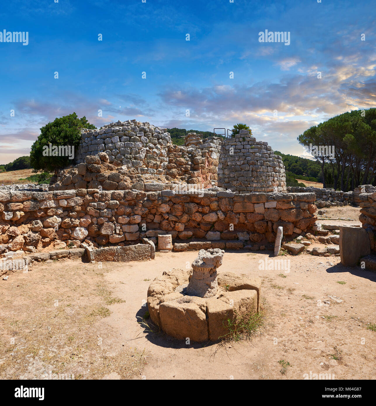 Pictures and image of the exterior ruins of Palmavera prehistoric Nuragic village meeting hall with Nuraghe tower behind,  archaeological site, middle Stock Photo