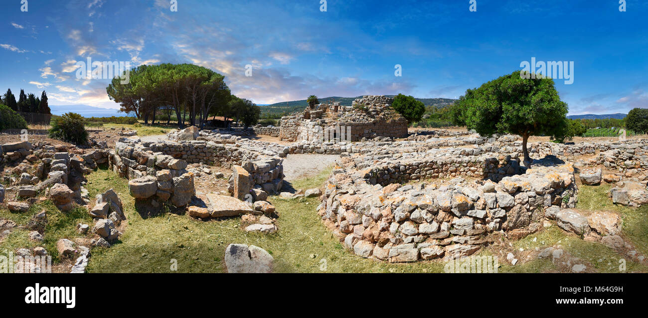 Pictures and image of the exterior ruins of Palmavera prehistoric round walled Nuragic village houses with its Nuraghe tower behind, archaeological si Stock Photo