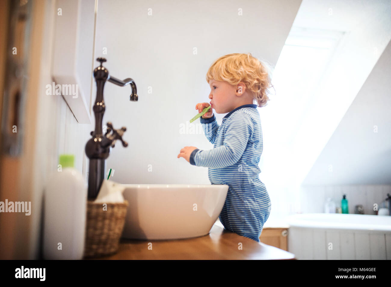 Cute toddler boy brushing his teeth in the bathroom. Stock Photo