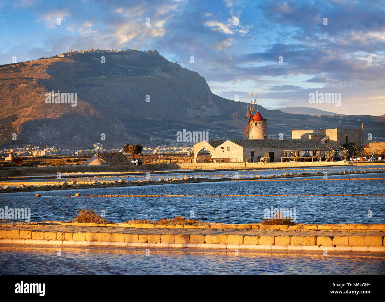 Pictures & images of the salt pans of the Nubia Salt works Museum and Nubia wind mill with Erice on the hills behind,  World Wildlife reserve of Salin Stock Photo