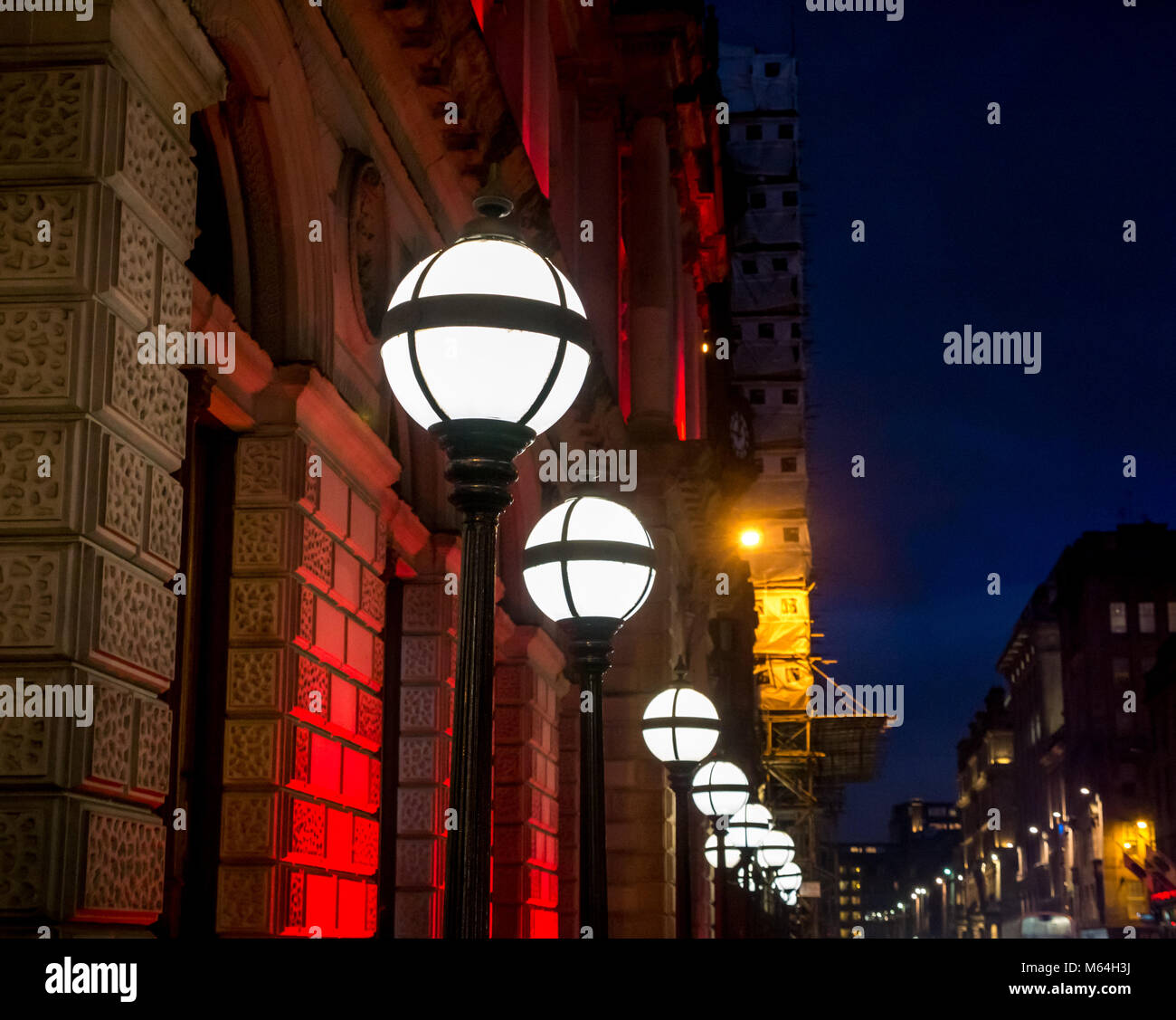 Row of old fashioned round lamps lit up at night, Clydesdale Bank head office, St Vincent Place, Glasgow, Scotland, UK with a dark sky Stock Photo