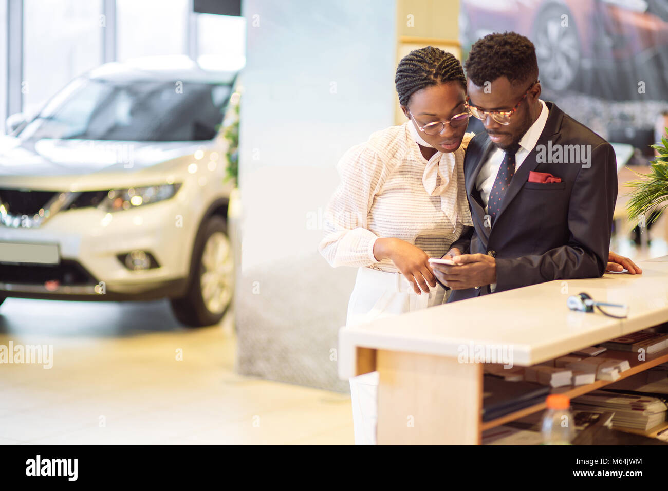 african Car rental assistant giving information to a couple customer