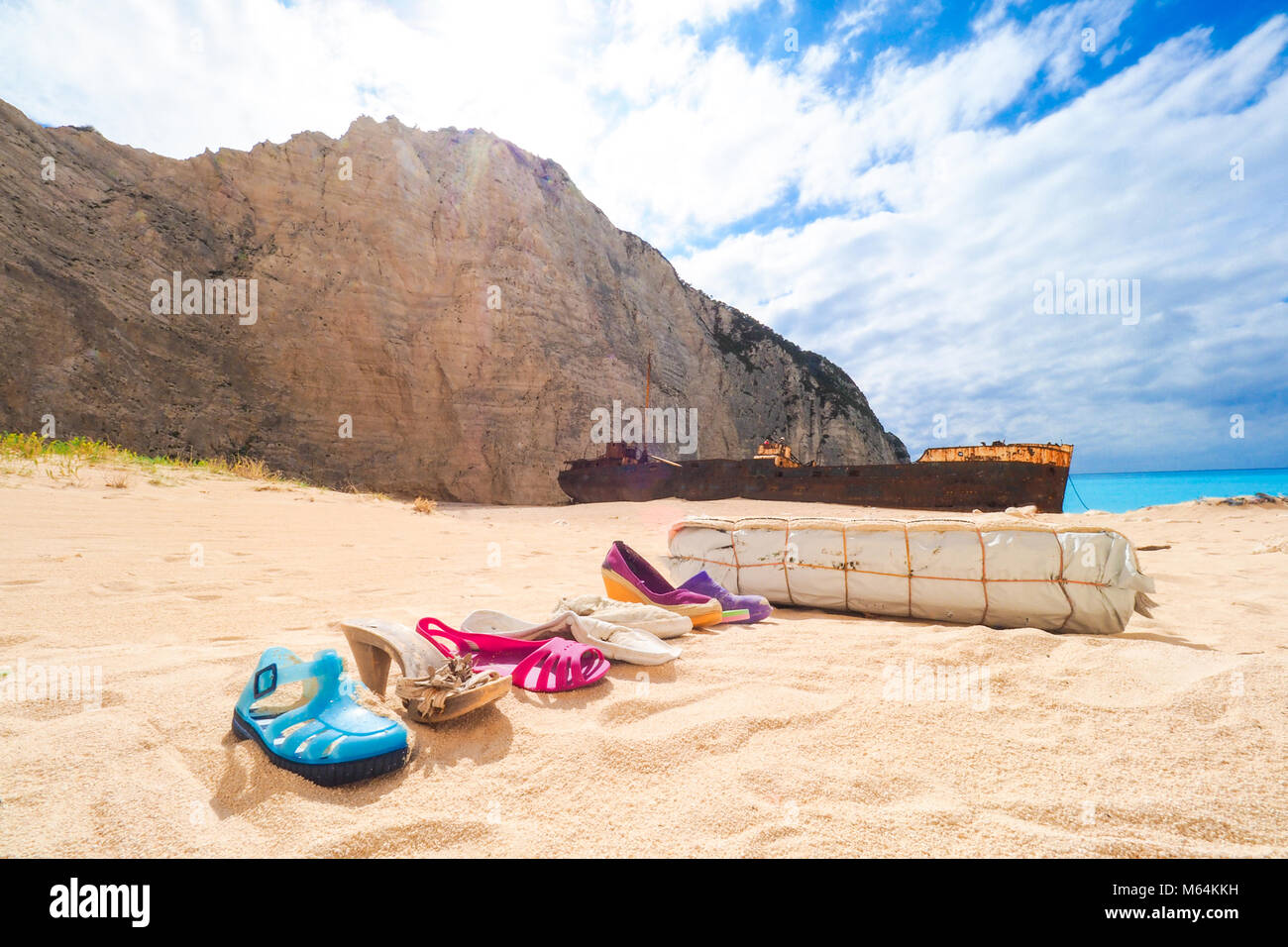 Trash left at Navagio beach, with Panagiotis shipwreck in back. Zakynthos, Greece. Artistic view. Stock Photo