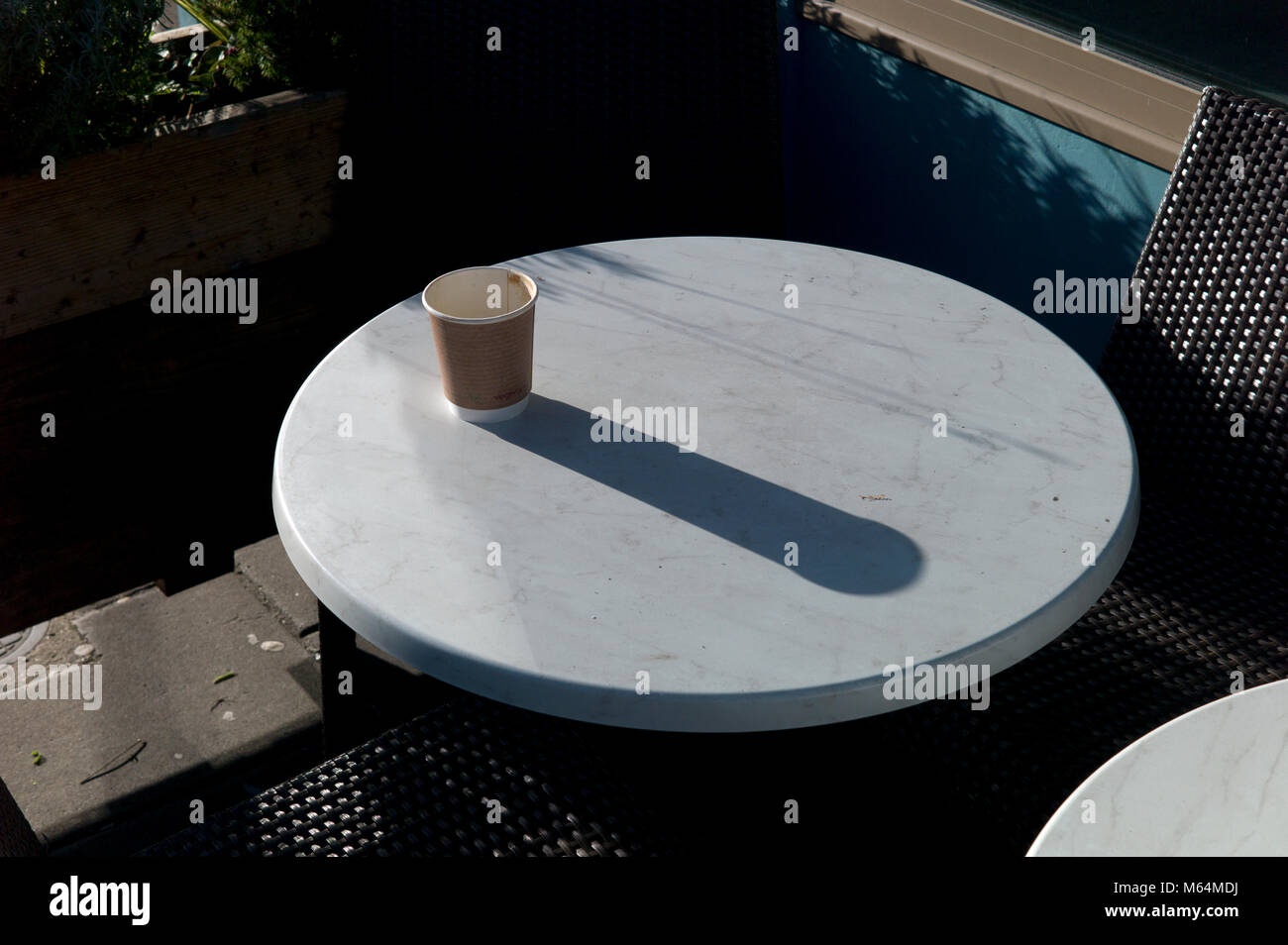 Empty take-away coffee cup on table, long shadow Stock Photo