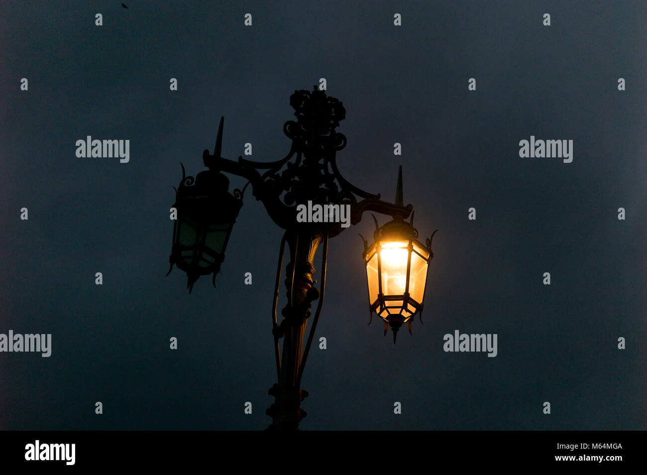 Ornate double victorian style streetlight, one lamp on, one lamp off Stock Photo