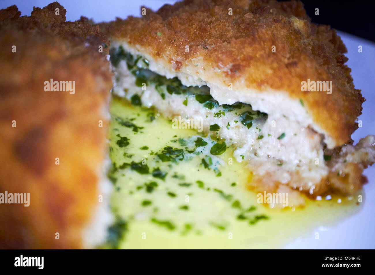cross section of cut through chicken kiev with garlic and herbs Stock Photo