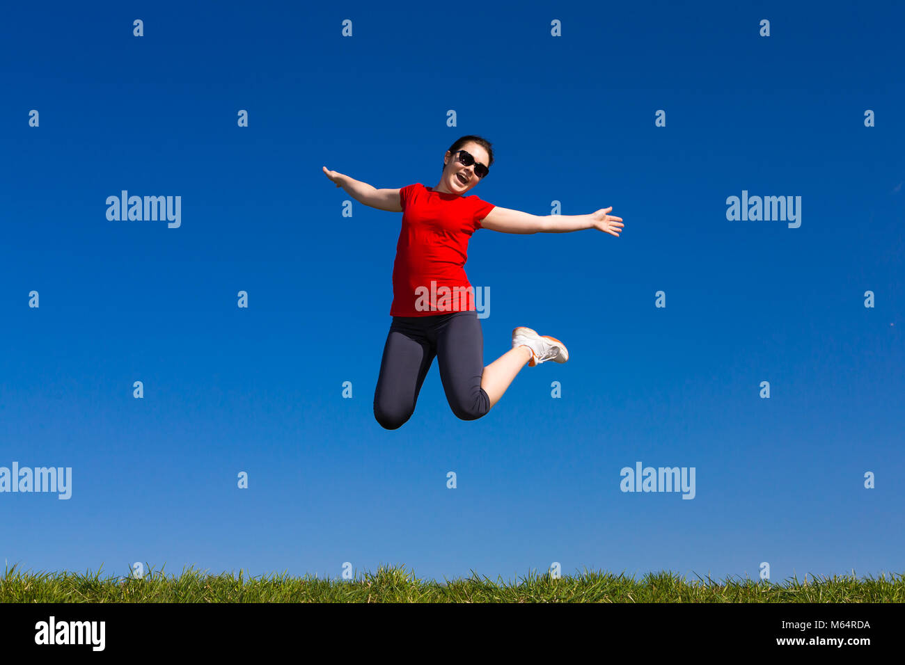 Teenage girl jumping outdoor against blue sky Stock Photo - Alamy