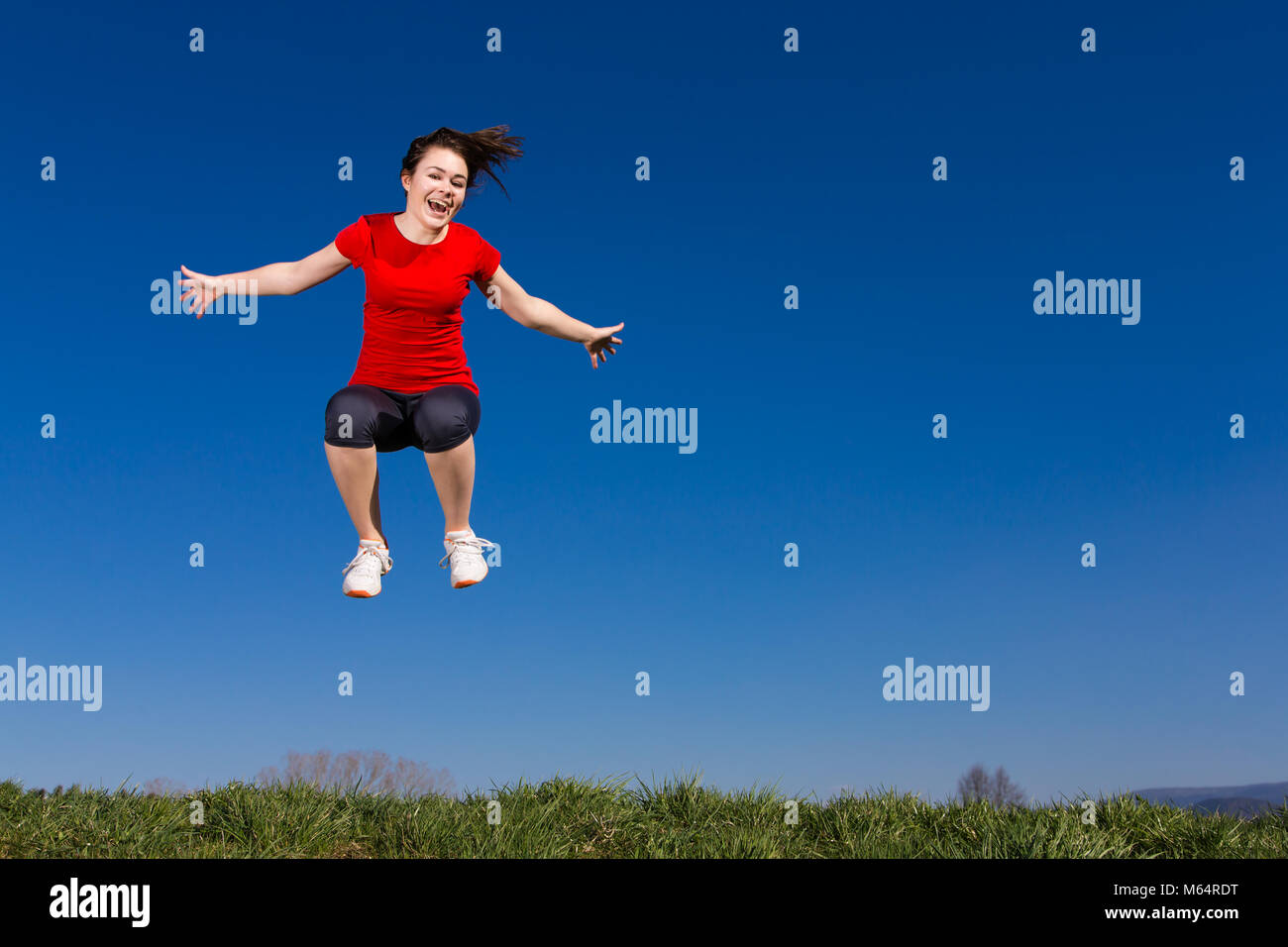 Teenage girl jumping outdoor against blue sky Stock Photo - Alamy