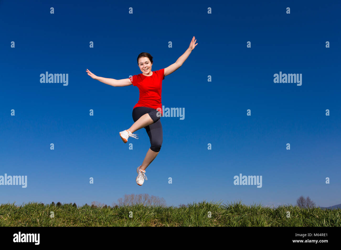 Teenage girl jumping outdoor against blue sky Stock Photo - Alamy