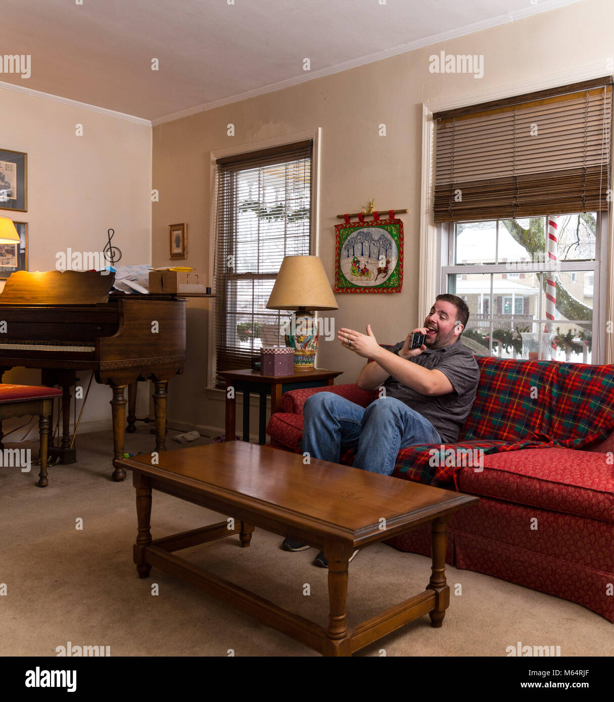 Young Caucasian Man Singing Karaoke Into His Phone While Sitting Alone
