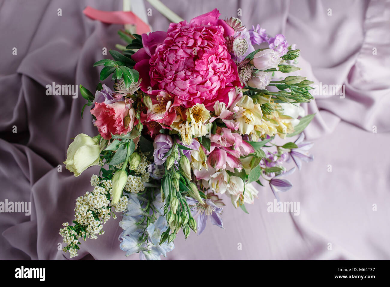 flower composition with peonies. Color pink, green, lavander, blue. beautiful luxury bouquet of mixed flowers. the work of the florist at a flower shop Stock Photo