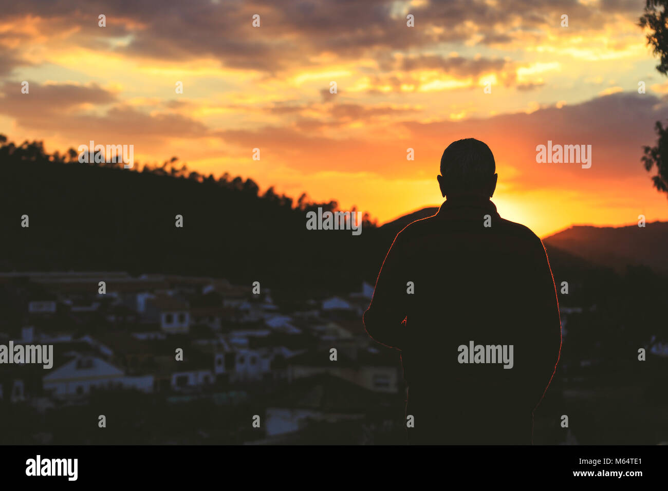 Silhouette of old man with his back to the sunset Stock Photo