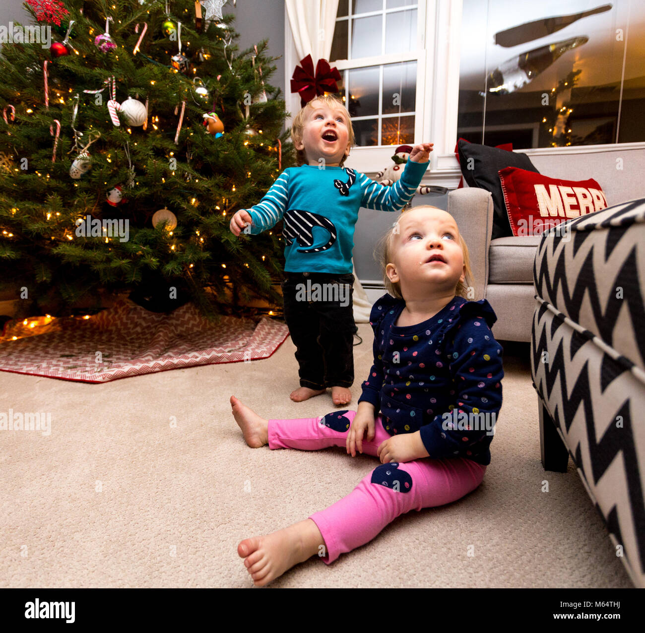 A Caucasian Girl and Boy Play With A New Years Eve Balloon in A Suburban Home Living Room Stock Photo