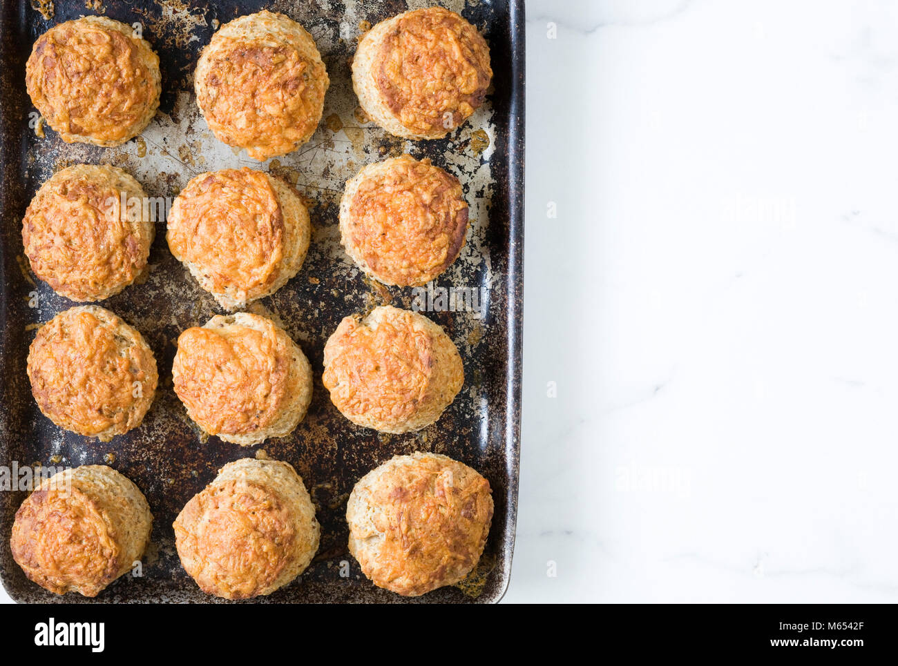 Freshly baked cheese scones on a baking tray. Stock Photo