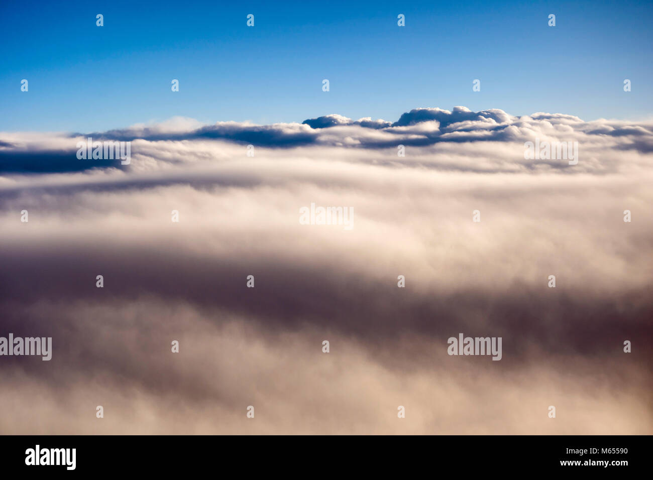 Aerial view over cumulus clouds from an airplane window during the ...